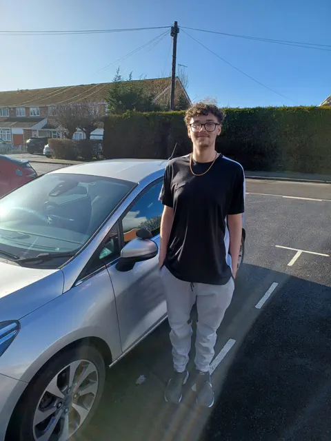 Student celebrating driving test pass with instructor Darius